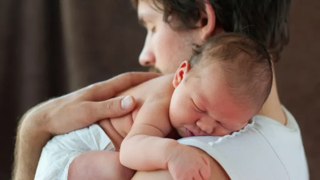 Dad holding baby on his shoulder